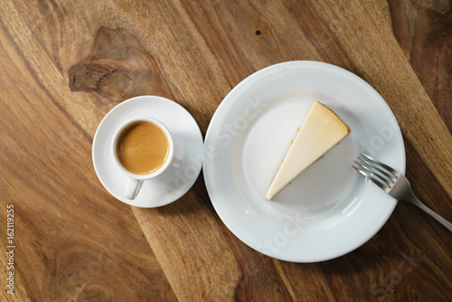 fresh espresso and cheesecake on table from above