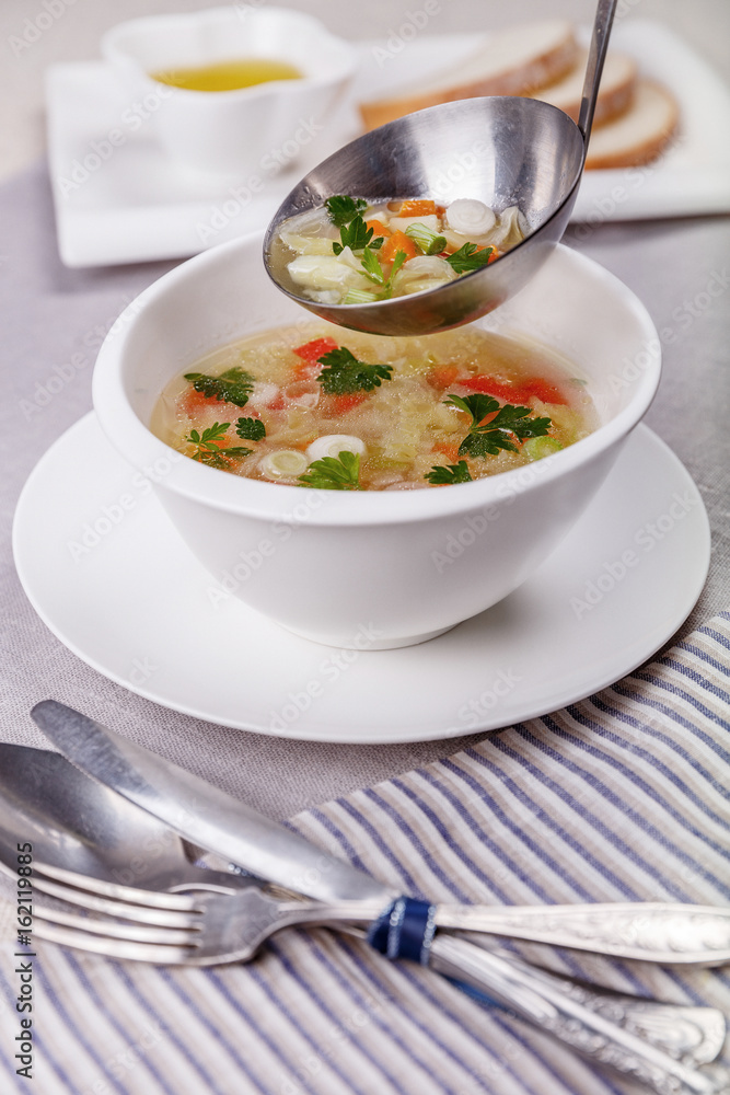 Fresh vegetable soup made of cabbage, carrot, potato, red bell pepper, tomato in bowl Fresh vegetable soup made of cabbage, carrot, potato, red bell pepper, tomato in bowl