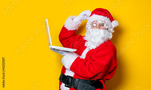 Funny Santa Claus have a fun with laptop