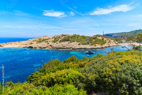 Green plants on cliff and view of boats on sea in Cala Portinatx bay, Ibiza island, Spain © pkazmierczak