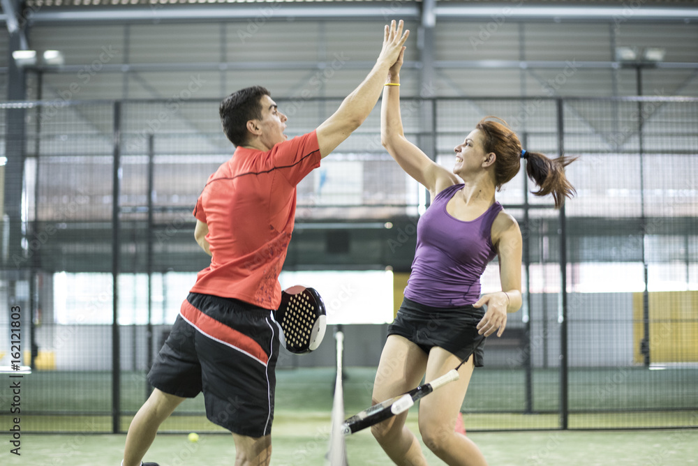 Before or after macth, couple hi five in paddle tennis court