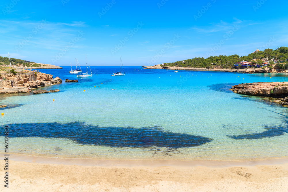 Idyllic Cala Portinatx beach with shallow crystal clear sea water, Ibiza island, Spain