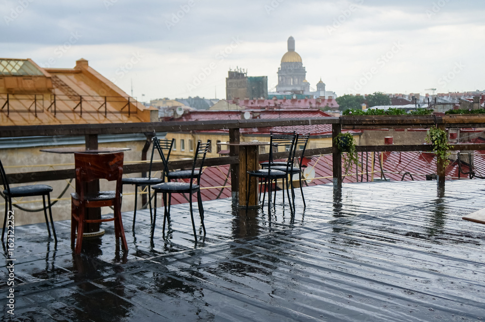 Rough wooden table, on the background of St. Petersburg, in a rooftop cafe on a rainy day. Summer 2016.
