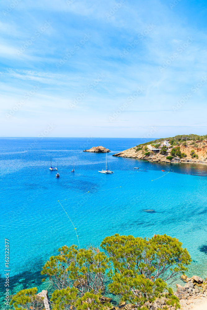 Sailing boats on Cala d'Hort bay with beautiful azure blue sea water, Ibiza island, Spain