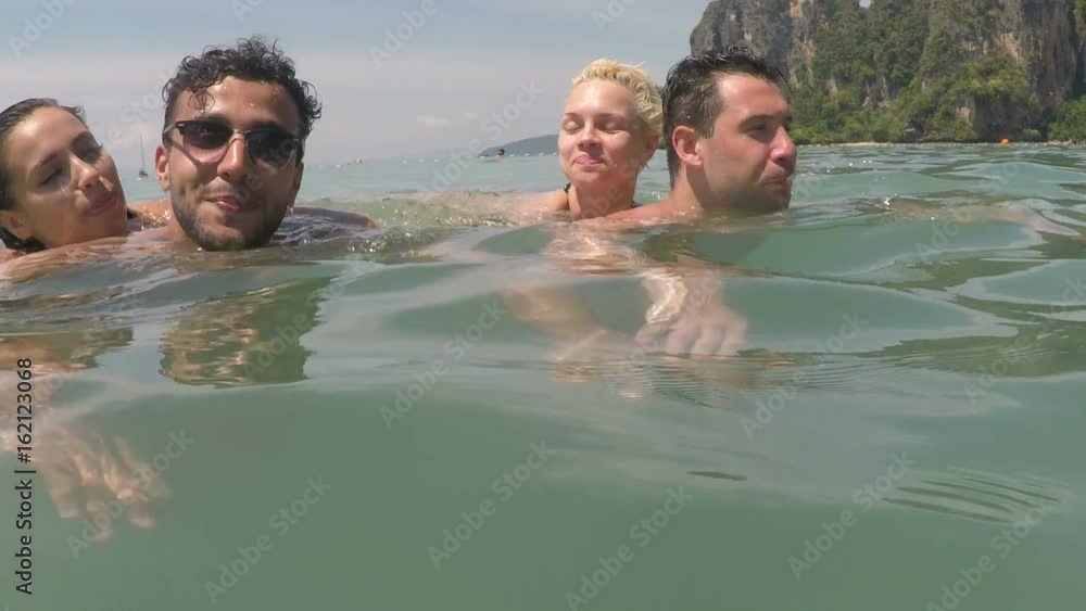 Two Men Carry Women Swimming In Sea Water Talking POV, Young People Tourists On Summer Vacation On Seaside Two Men Carry Women Swimming In Sea Water Talking POV, Young People Tourists On Summer Vacation On Seaside