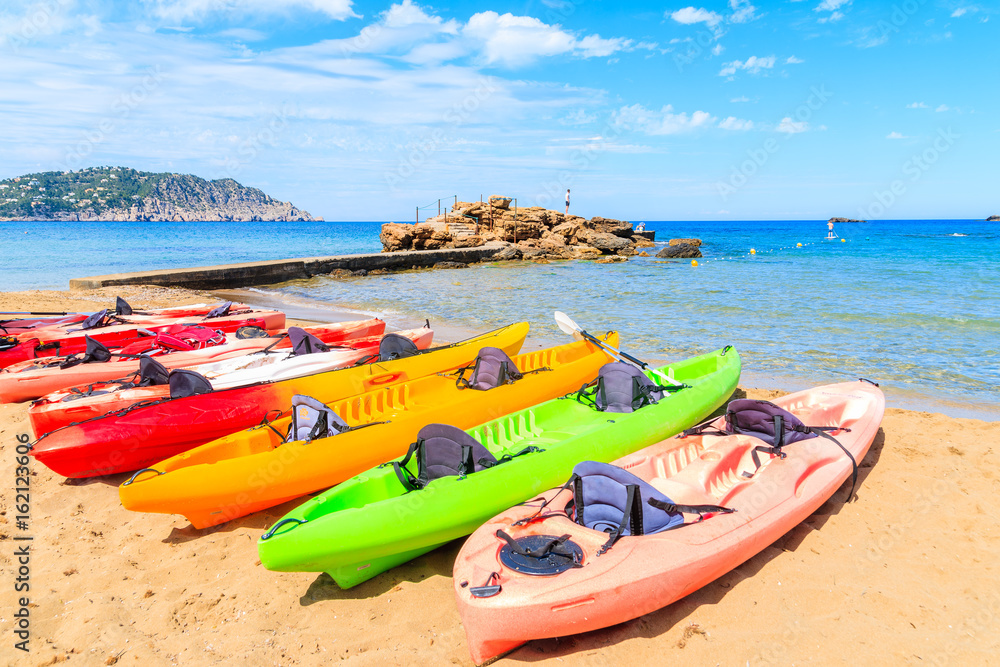 Colourful kayaks on sandy Es Figueral beach, Ibiza island, Spain Colourful kayaks on sandy Es Figueral beach, Ibiza island, Spain