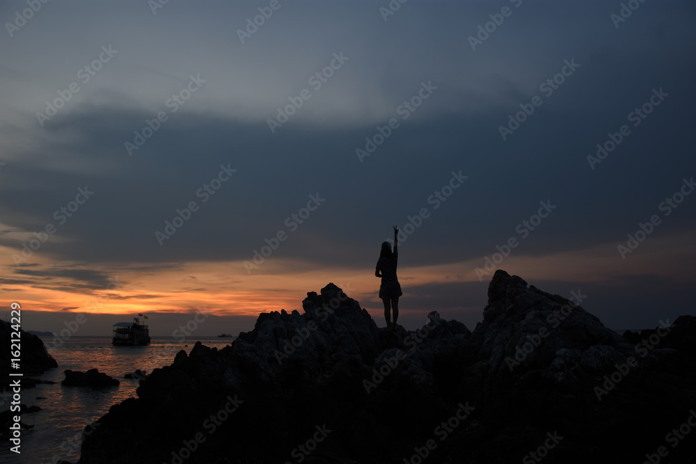 silhouette of woman watching warm sunset with seaside silhouette of woman watching warm sunset with seaside