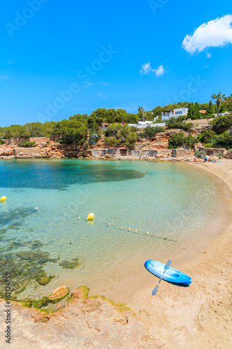 Blue kayak on shore of beautiful Cala Gracioneta beach, Ibiza island, Spain photo