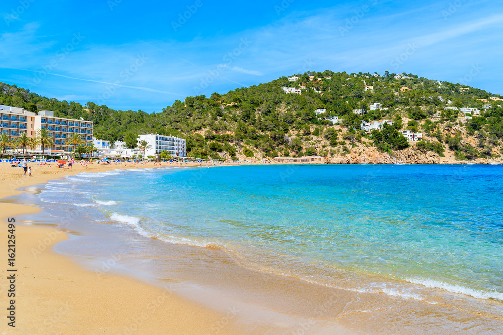 View of Cala San Vicente beach with hotels in distance, Ibiza island, Spain