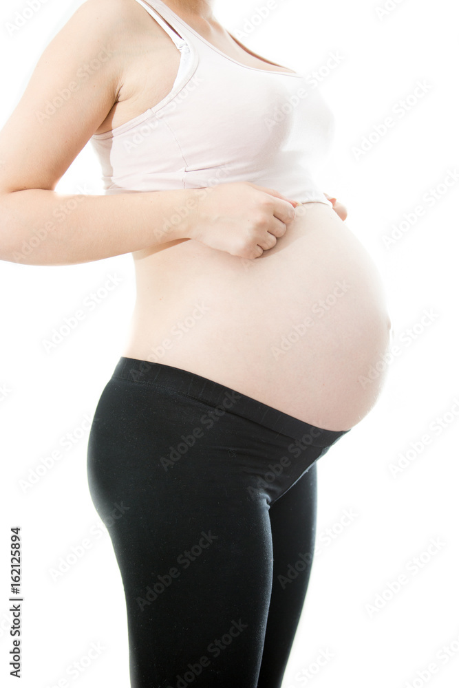 Young pregnant woman showing big belly over white background Young pregnant woman showing big belly over white background