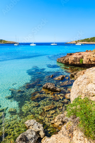 View of rocks in turquoise sea water on coast of Cala Portinatx bay, Ibiza island, Spain