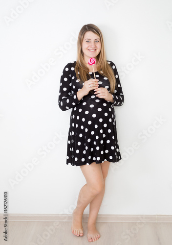 Wallpaper Mural Beautiful smiling pregnant woman holding big lollipop Torontodigital.ca