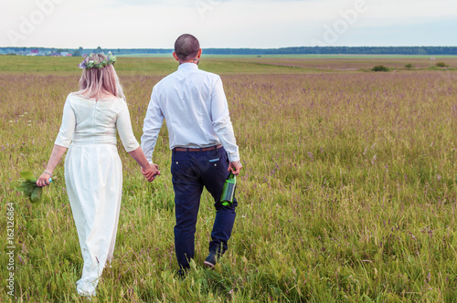 newlyweds in the field to hold hands