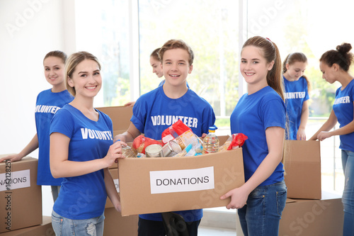 Young volunteers with box o...