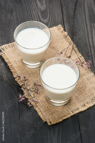 Dairy products. Two glasses of milk on a rustic wooden table.