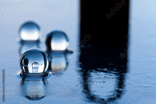 Water pearls abstract with locker and reflection on dark surface