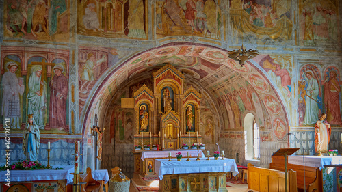 Kleine Kirche Wände bemahlt mit Heiligenfiguren und sakrale Kunst in einem Bergdorf in Österreich 