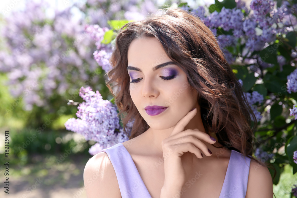 Beautiful young woman with lilac make up in spring garden Beautiful young woman with lilac make up in spring garden