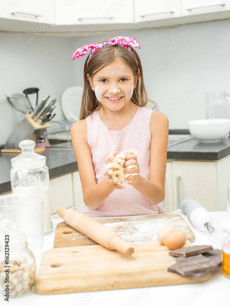 Portrait of happy smiling girl making dough for pie on kitchen Portrait of happy smiling girl making dough for pie on kitchen