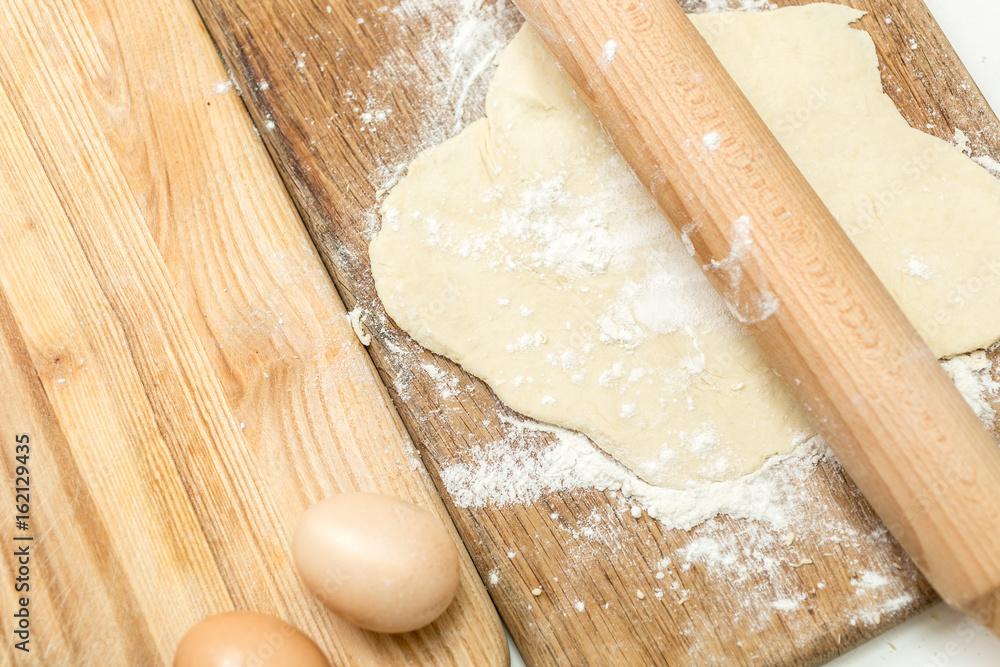 Closeup of dough lying on wooden cooking board Closeup of dough lying on wooden cooking board