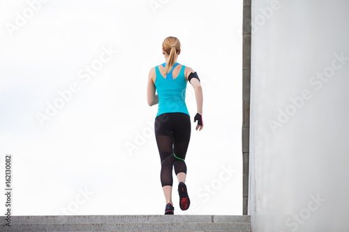 Young fitness healthy woman runner running on city