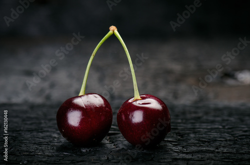 Cherries on a black table.. Natural wooden burnt table. Fresh food concept. Fruit. Summer time 