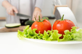 Closeup image of fresh tomatoes and lettuce on kitchen table