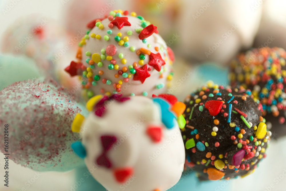 Macro shot of cake pops decorated by colorful sprinkles