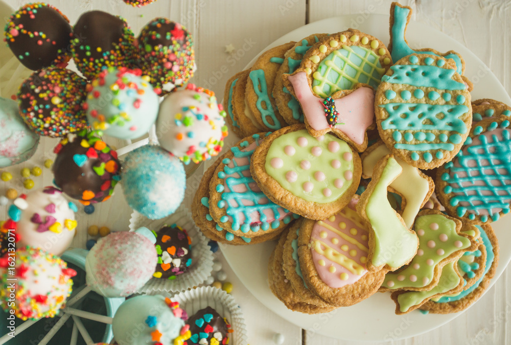 Beautiful decorated cake pops and cookies for Easter on table