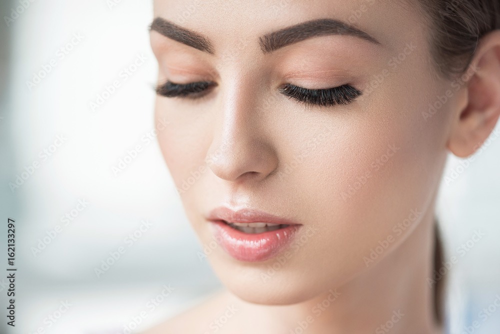 Thoughtful beautiful girl using visage cosmetics