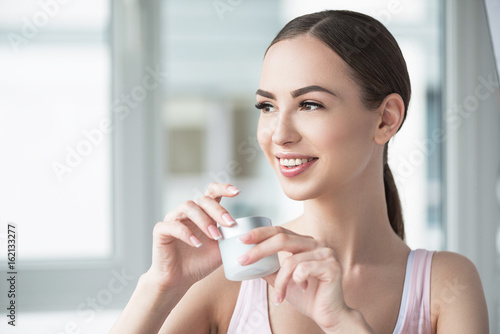 Happy youthful lady caring about her skin