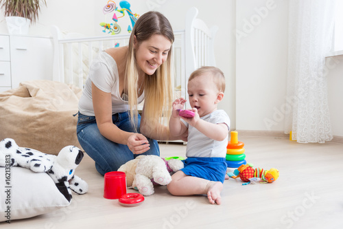 Mother playing with her baby boy at home