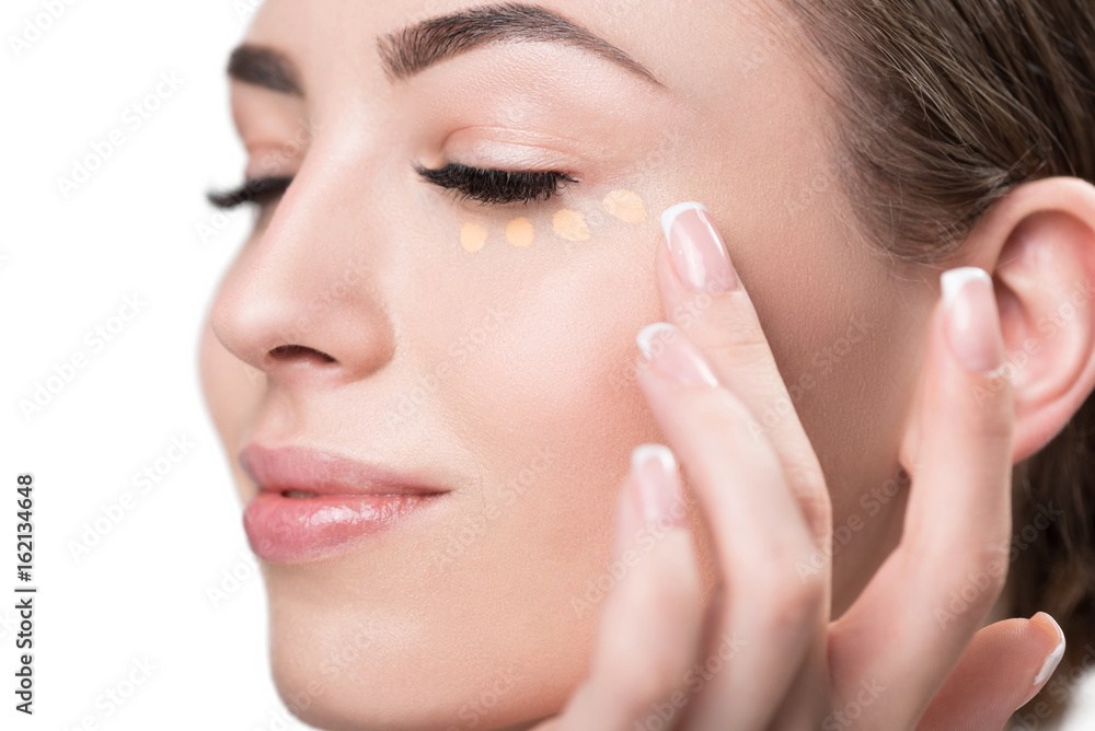 Happy beautiful girl applying facial cosmetic Happy beautiful girl applying facial cosmetic
