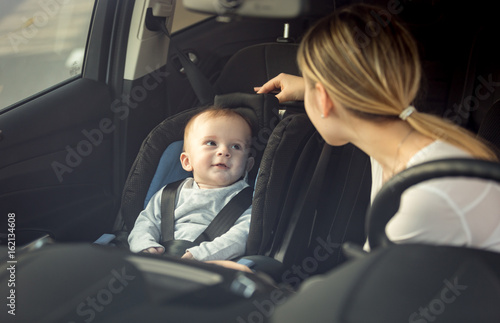 Portrait of mother and baby boy sitting in car on front seats