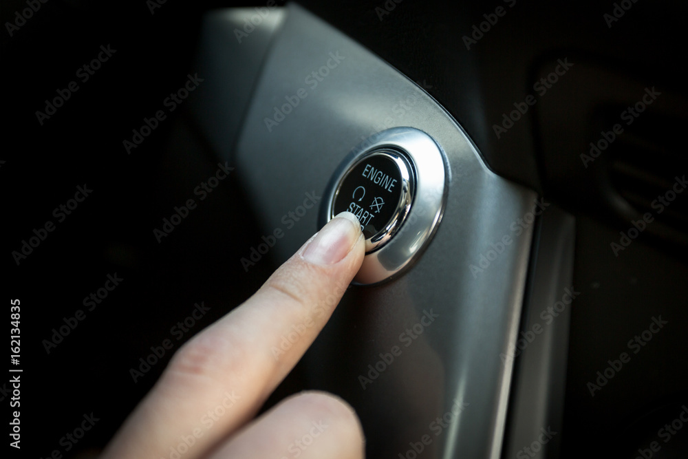 Closeup of driver starts the engine by pressing button