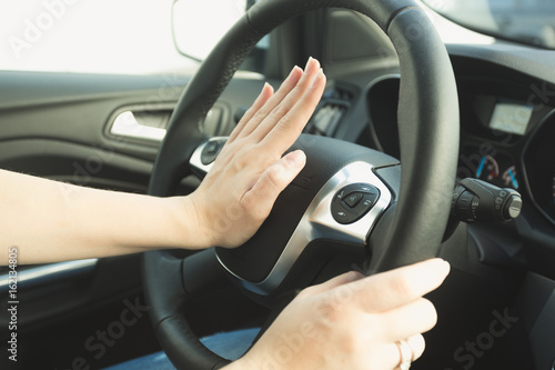 Quadro em tela Woman pressing honk button on steering wheel