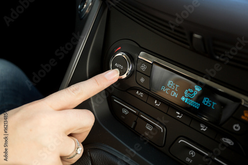 Closeup of woman adjusting temperature on car climate control system © Кирилл Рыжов