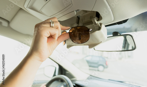Tableau sur toile Woman taking sunglasses out of special car compartment