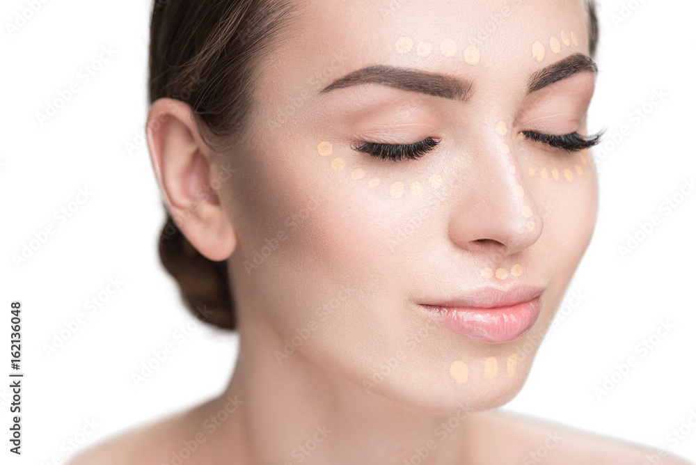Beautiful young lady has concealer on face Beautiful young lady has concealer on face