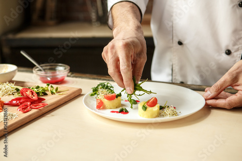 Mature man professional chef cooking meal indoors