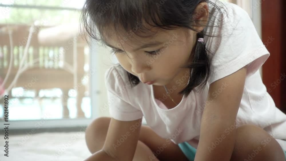 Cute asian little girl pay attention to paint her picture with crayon Cute asian little girl pay attention to paint her picture with crayon