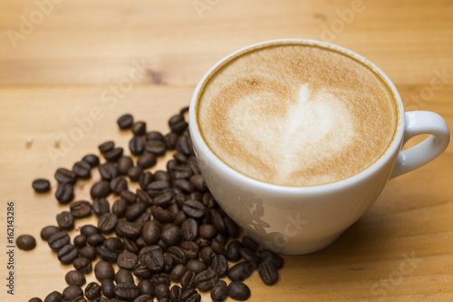 Latte art with coffee beans on wood table