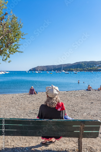 Wallpaper Mural femme assise sur banc, plage de Cadaqués, Espagne  Torontodigital.ca