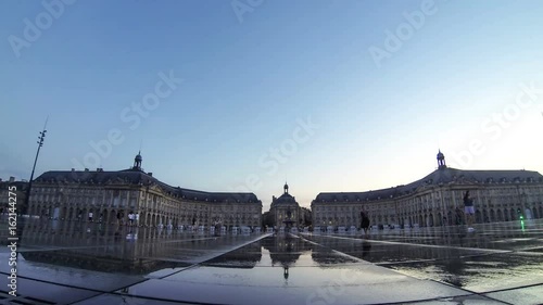 People walks on near water mirror fountain on Place de la Bourse in Bordeaux, Nouvelle-Aquitaine region, France. One of the most popular attractions in Bordeaux. 4K UltraHD
