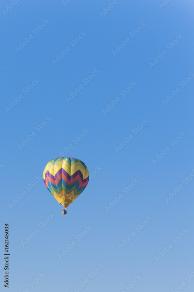 Fototapeta premium Isolated Hot Air Balloon in a blue sky