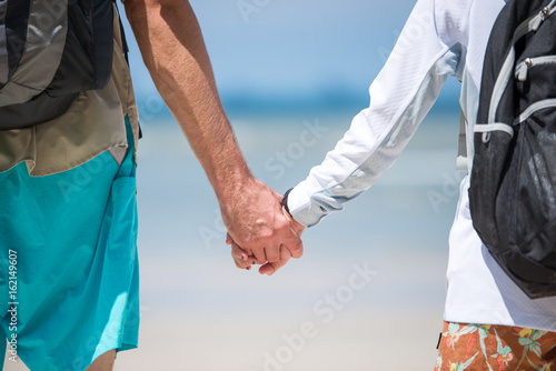 Young couple holding hands go to the beach