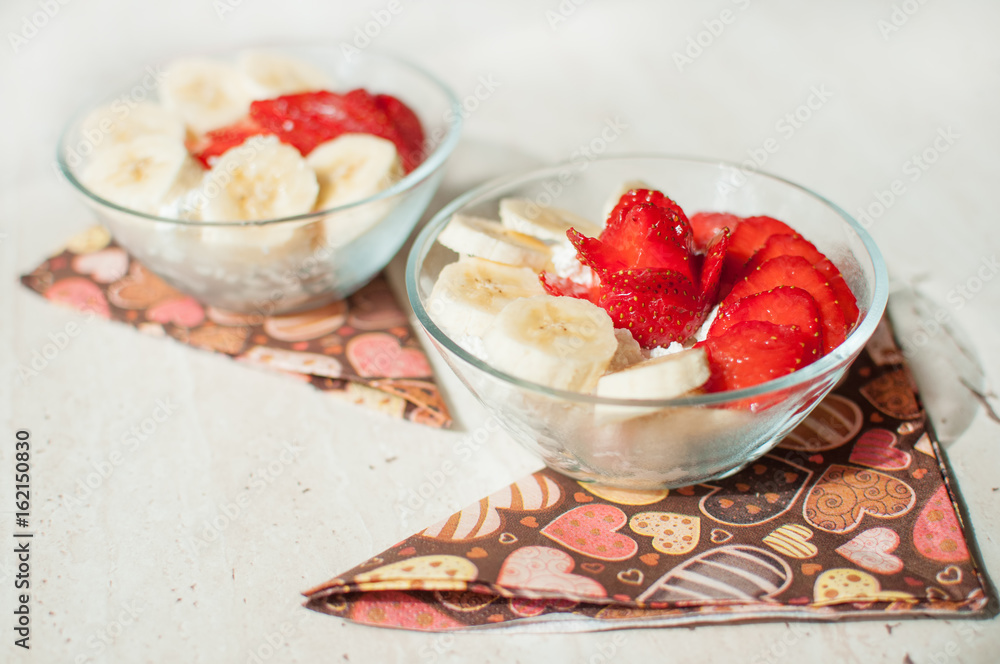 Two bowls of curd with strawberry and banana. Two bowls of curd with strawberry and banana.
