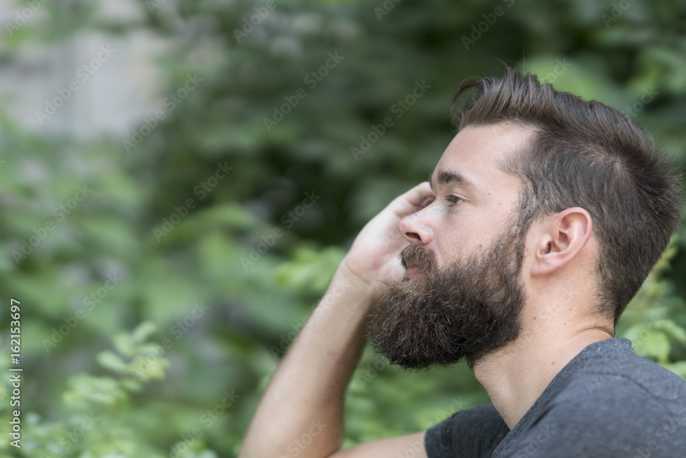 Close up portrait of a thoughtful bearded guy resting in park Close up portrait of a thoughtful bearded guy resting in park