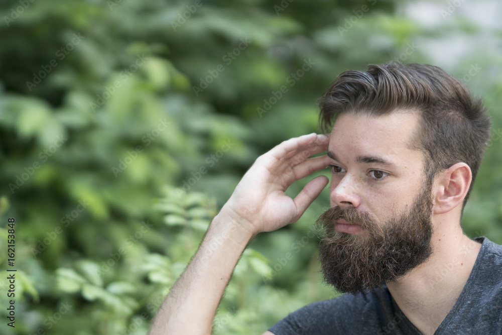 Close up portrait of a thoughtful bearded guy resting in park Close up portrait of a thoughtful bearded guy resting in park