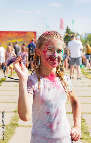Joyful girl sprinkled with dry paint